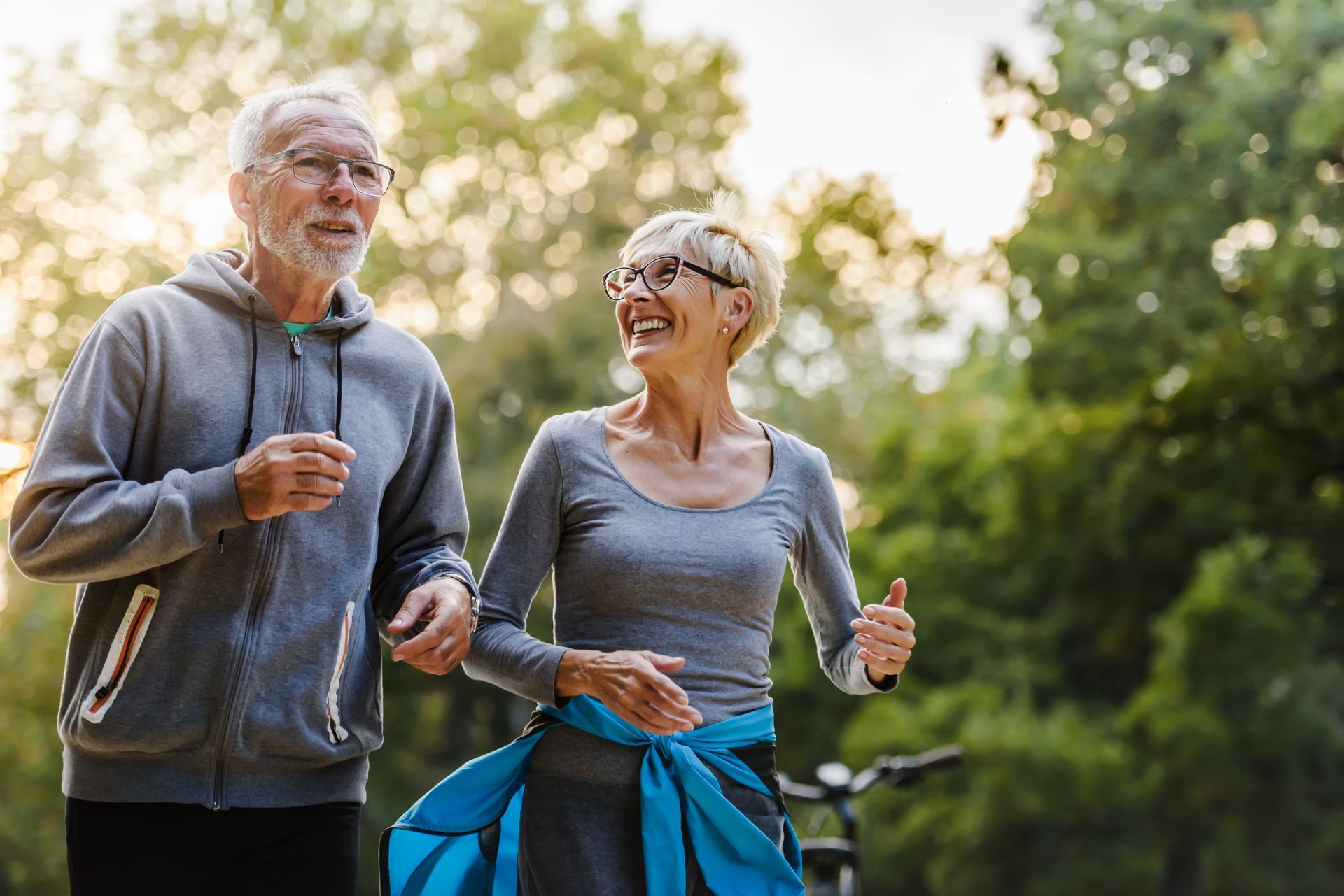 A man and a woman are walking in a park.
