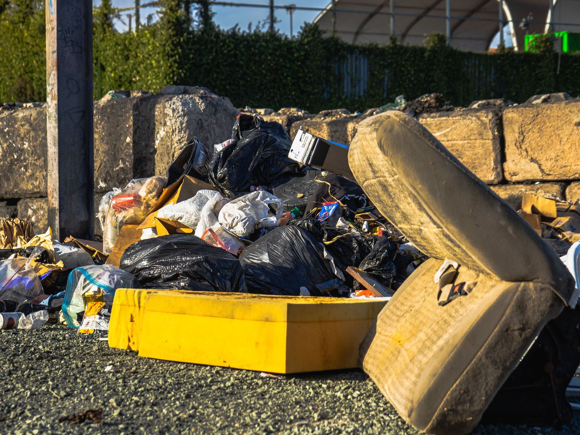Overflowing cardboard boxes and trash piled in front of a white garage door