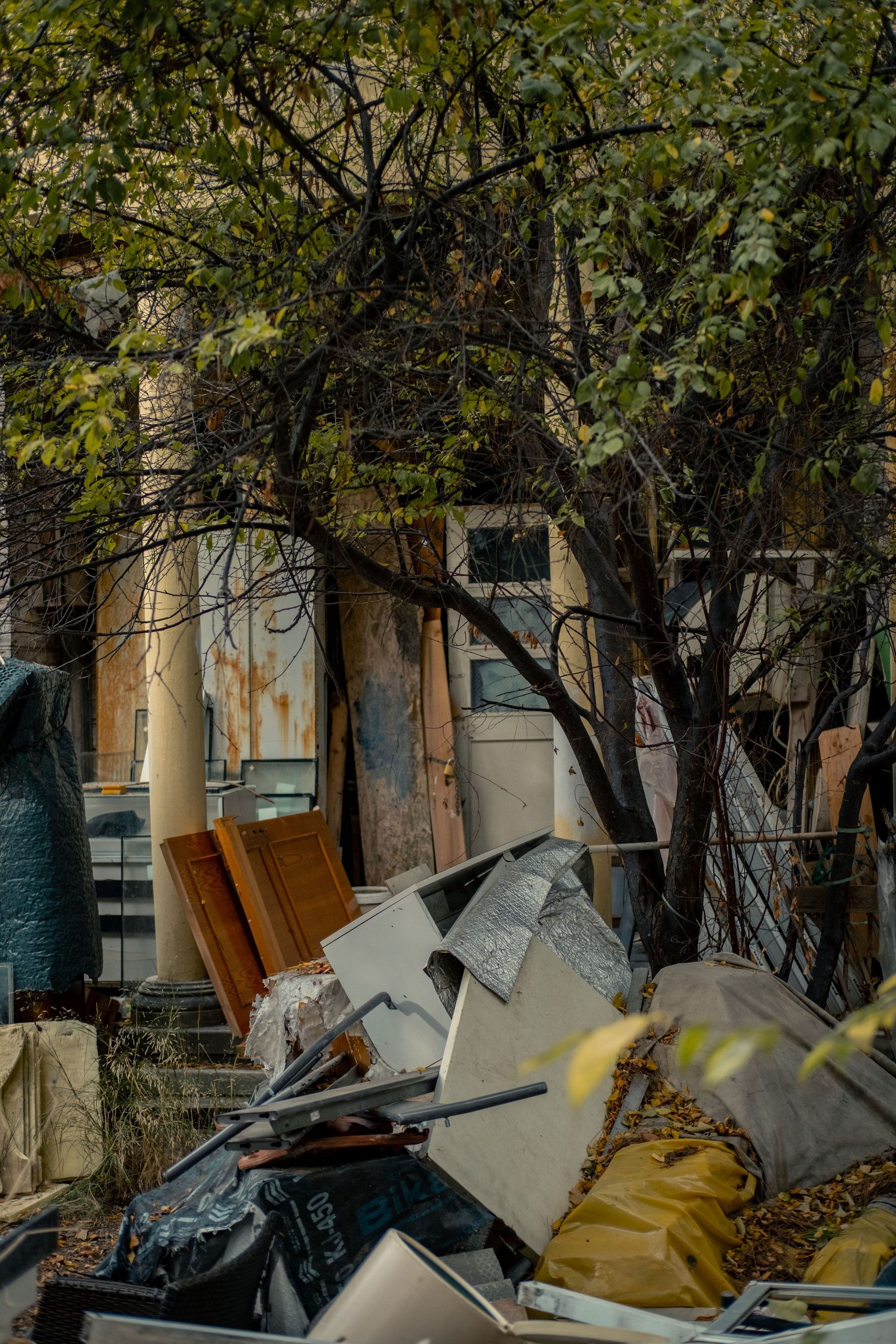 Overflowing cardboard boxes and trash piled in front of a white garage door
