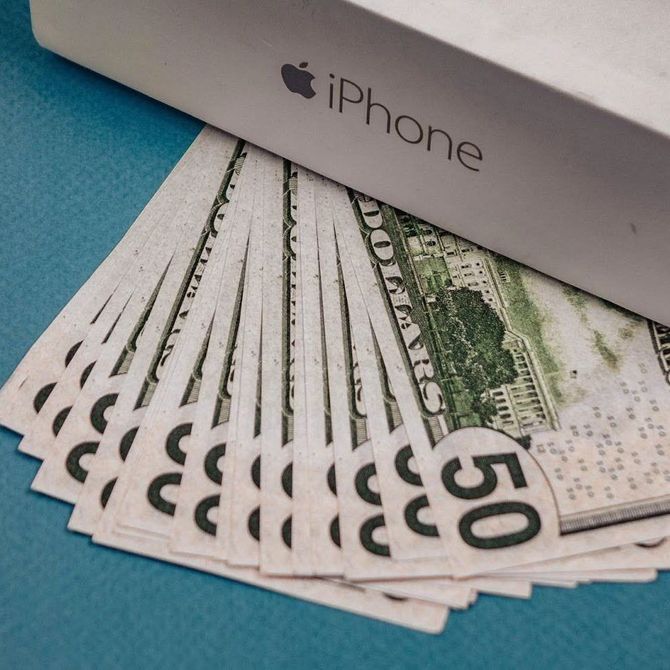 IPhone box on top of a fan of U.S. $50 bills