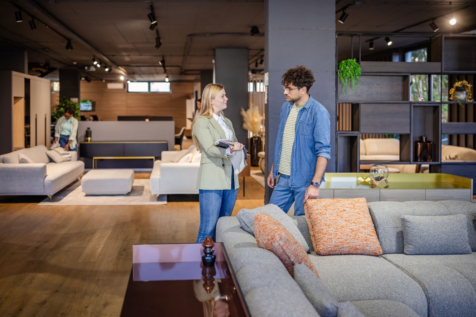 Man and woman discuss fabric samples in showroom.