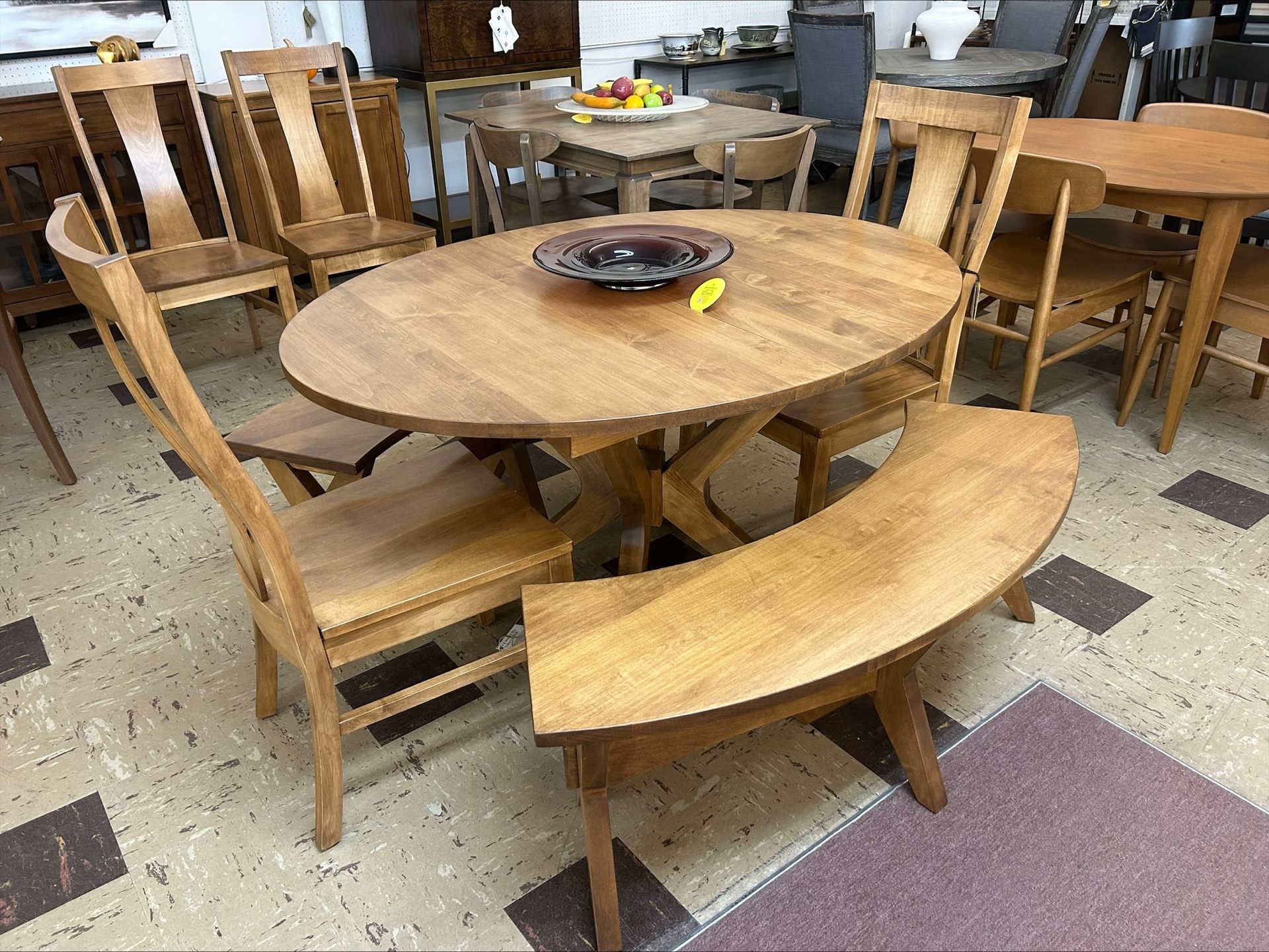 Round wooden picnic table with curved benches in a cafeteria or dining hall