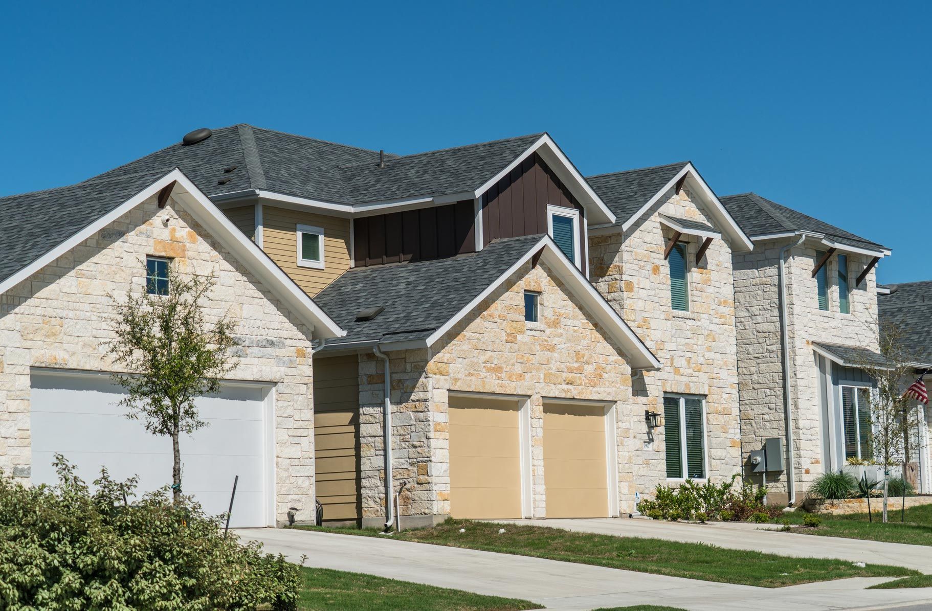 A row of houses in a residential area with a blue sky in the background.