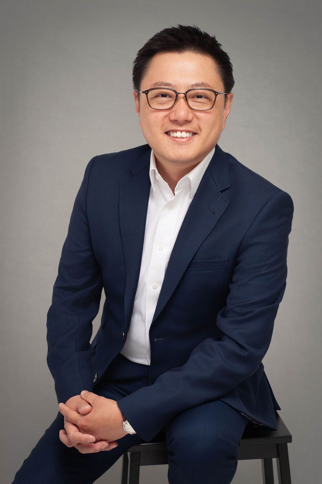A man in a suit and tie is smiling for the camera.
