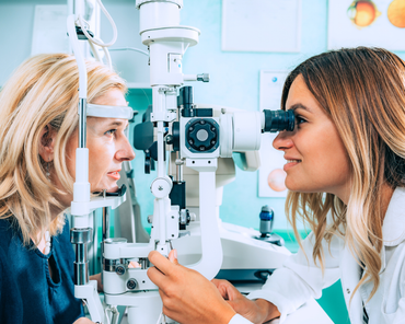 A woman is getting her eyes examined by an ophthalmologist.