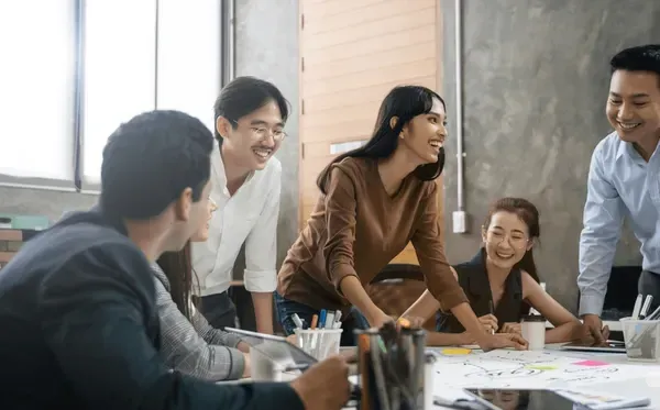 A group of people are sitting around a table having a meeting.