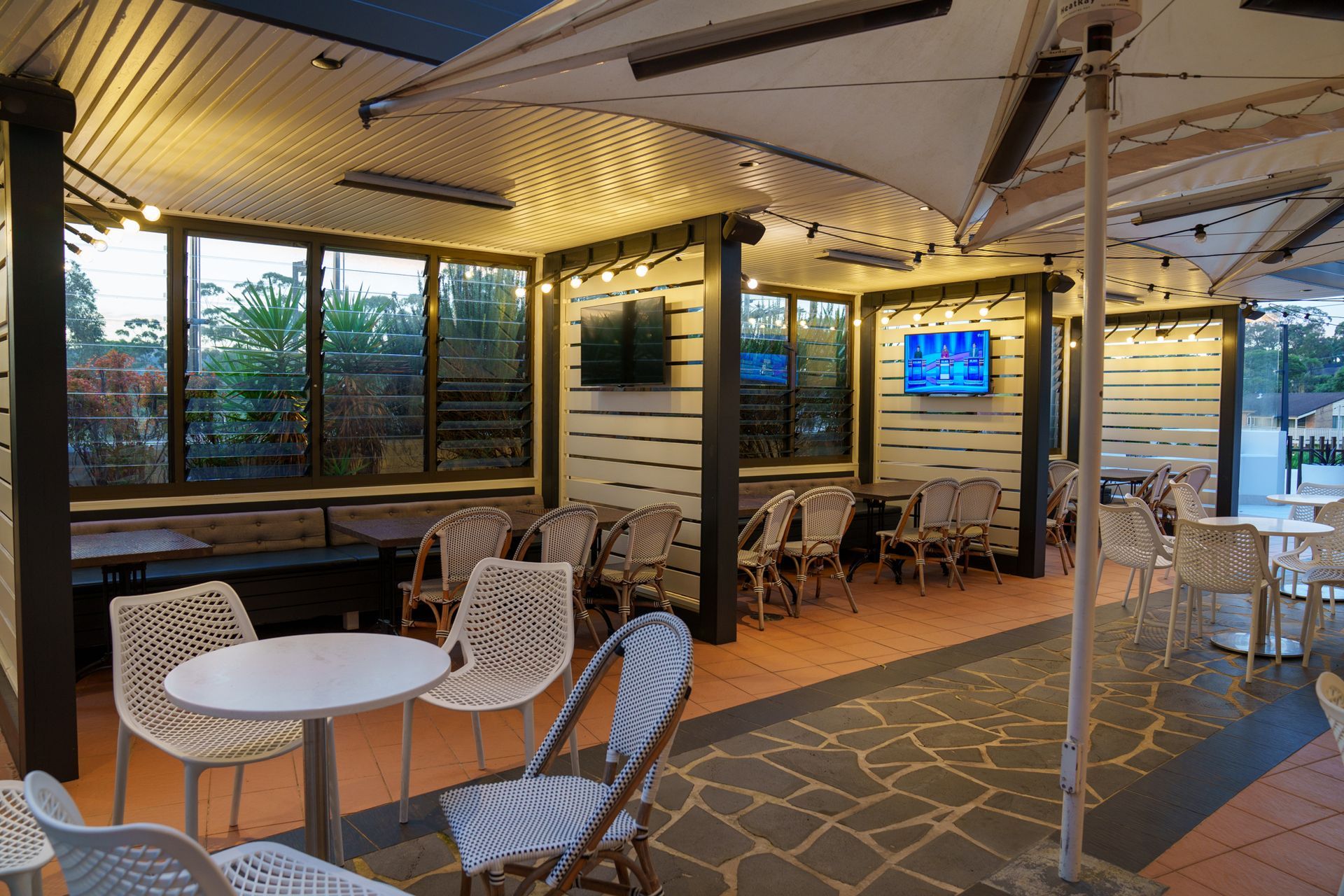 Covered terrace event space with greenery, seating and natural light