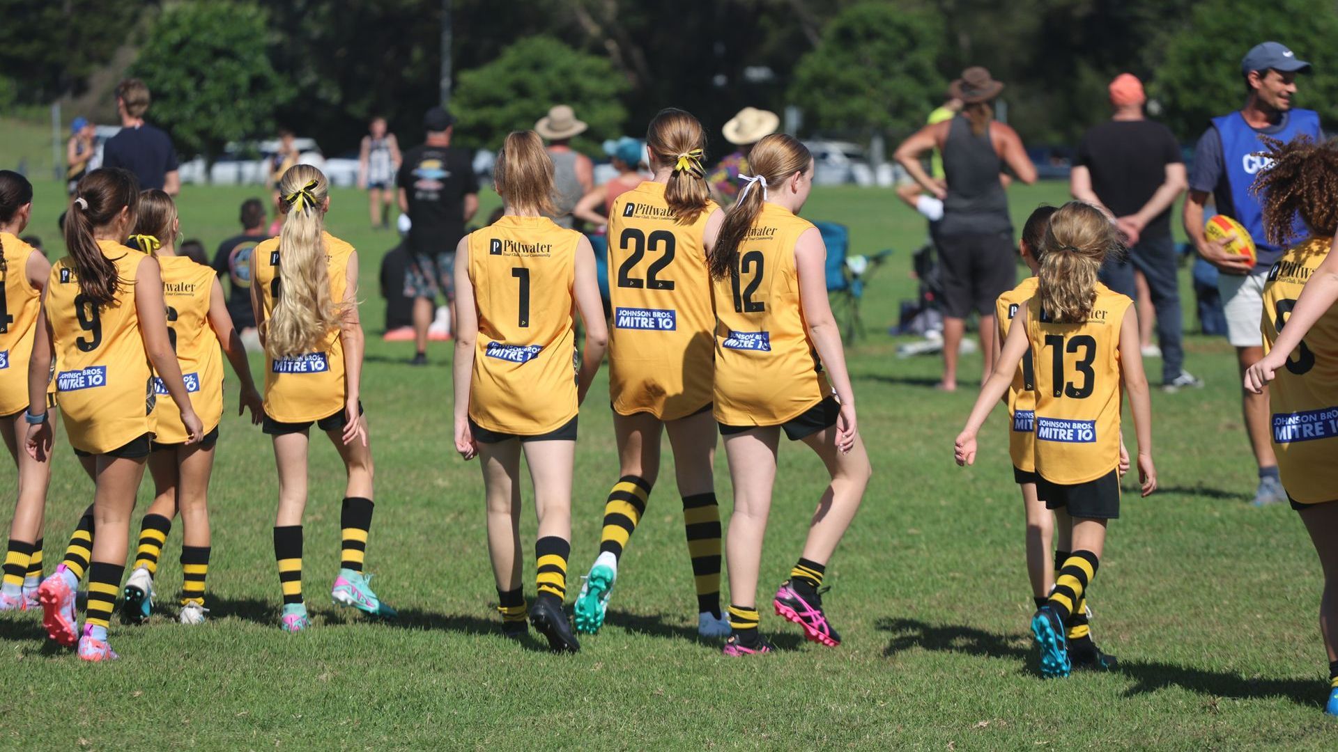 Junior rugby league players in Pittwater Tigers uniforms walking together on a sports field