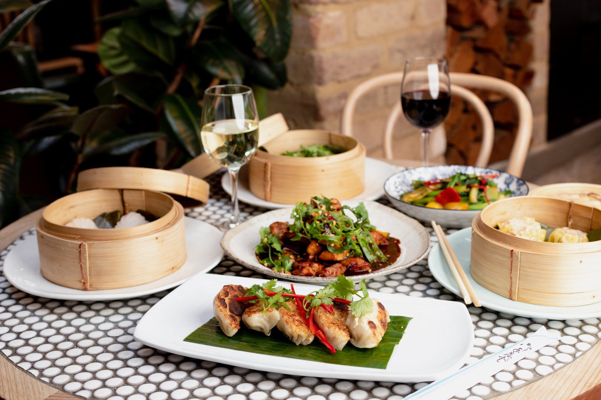 Wok O’clock banquet-style spread featuring bamboo steamers, fresh Asian dishes and shared plates