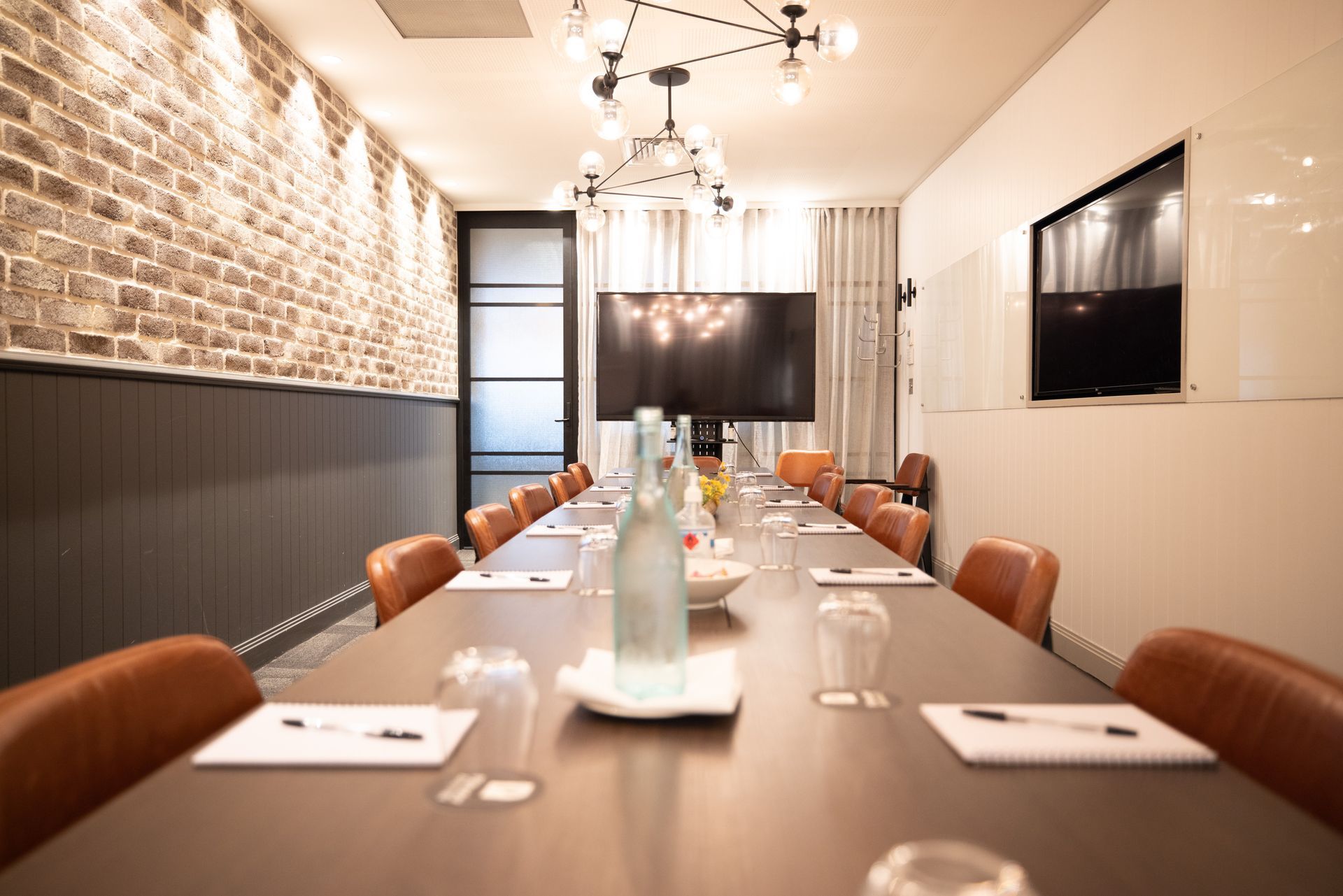 Boardroom-style private dining room set with long table and leather chairs