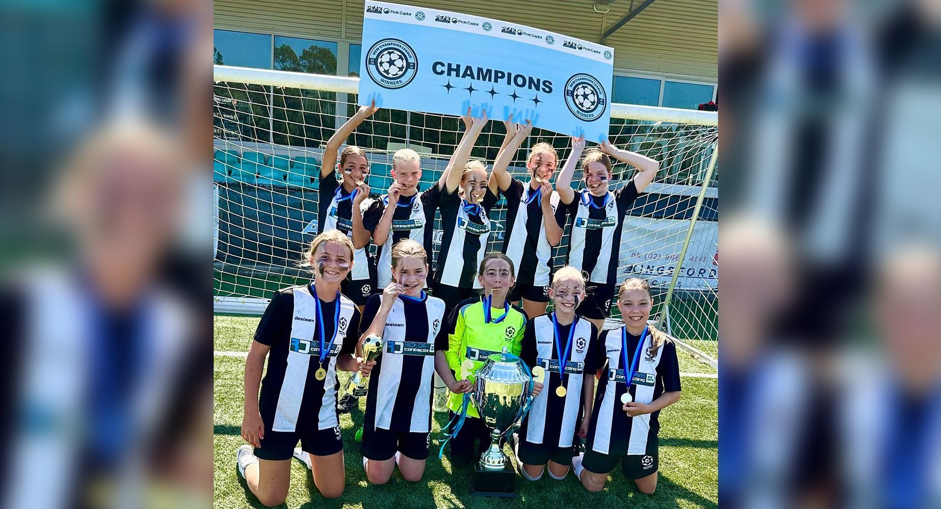 Narrabeen Football Club players celebrating with a championship trophy on a soccer field