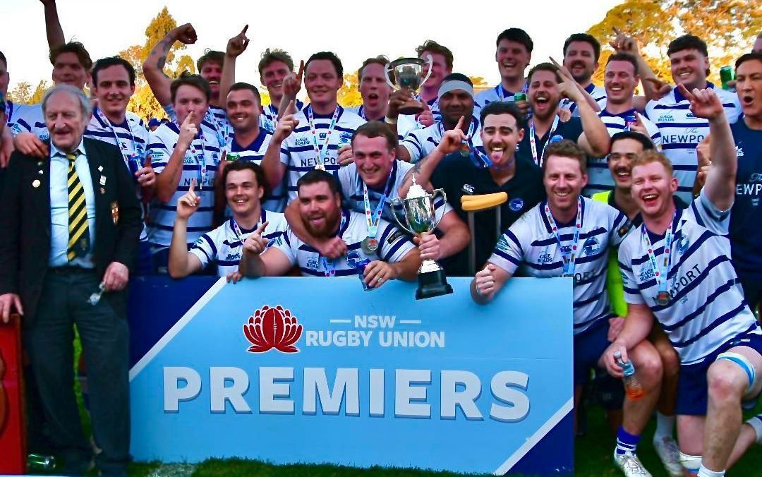 Newport Breakers rugby team celebrating a premiership win holding a ‘Premiers’ banner