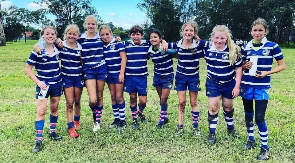 Newport Junior Rugby Club players standing together on a grass field in team uniform