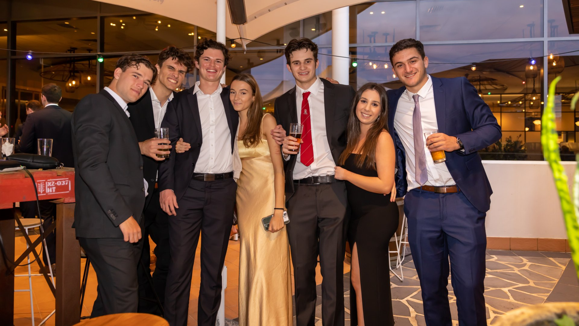 Friends posing with drinks at a formal social function at Mona Vale RSL Club