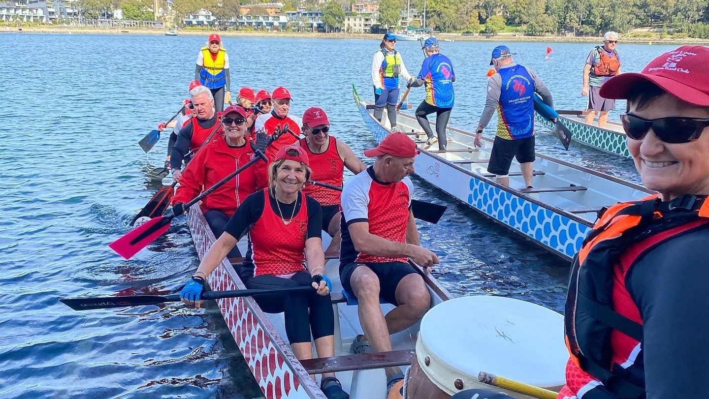 Dragon boat team paddling together on the water during a club race