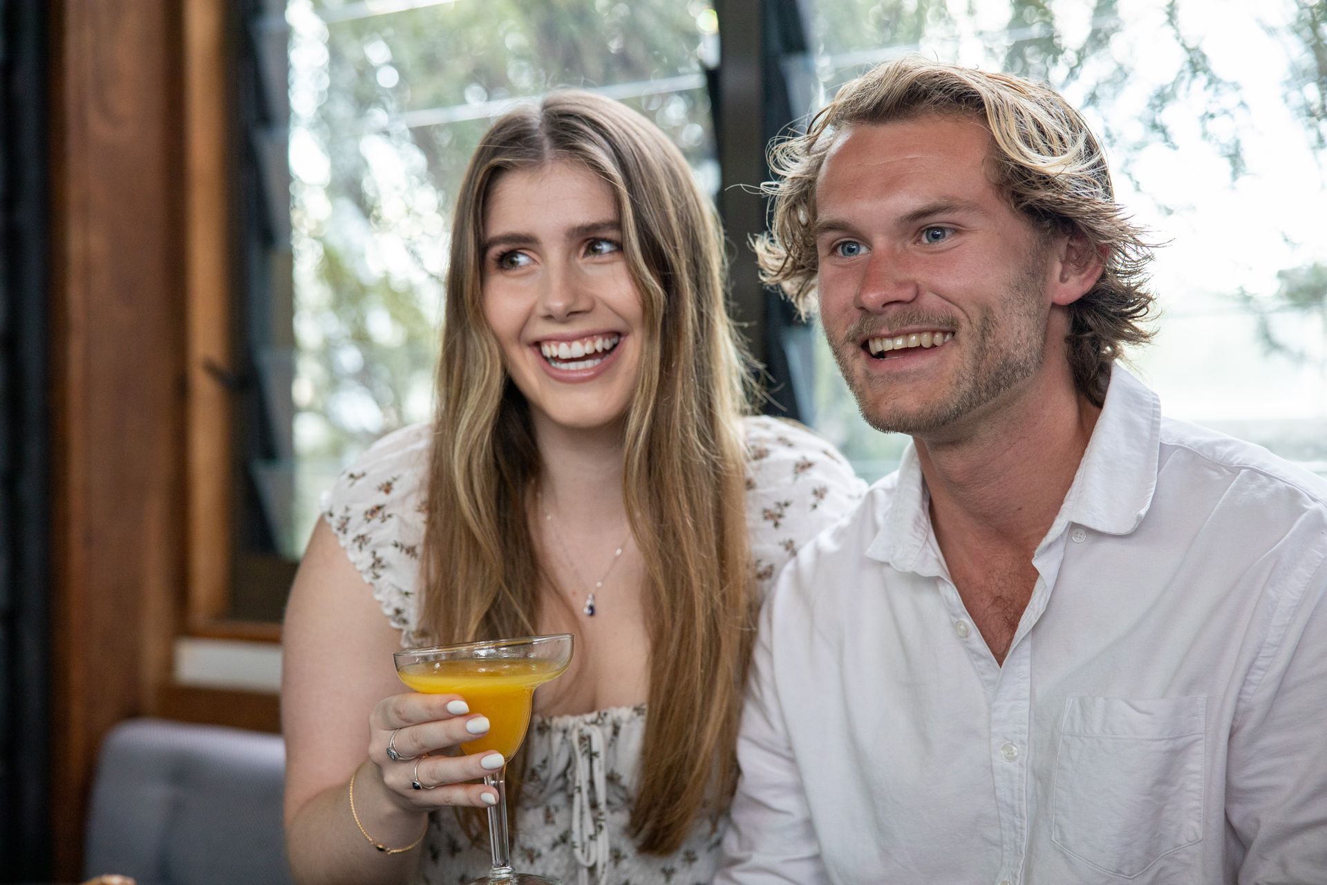 Smiling couple enjoying cocktails together inside a relaxed Mona Vale venue