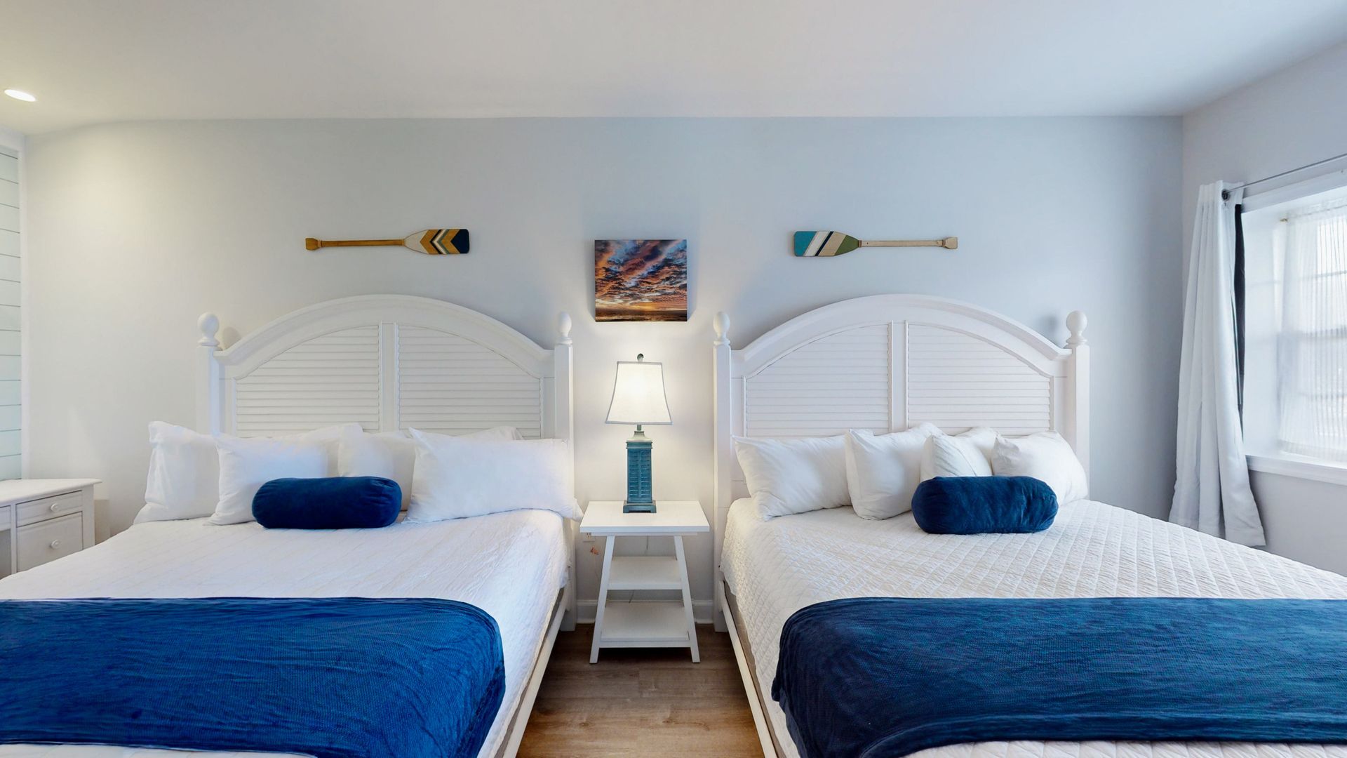 A bedroom with two beds and a window.