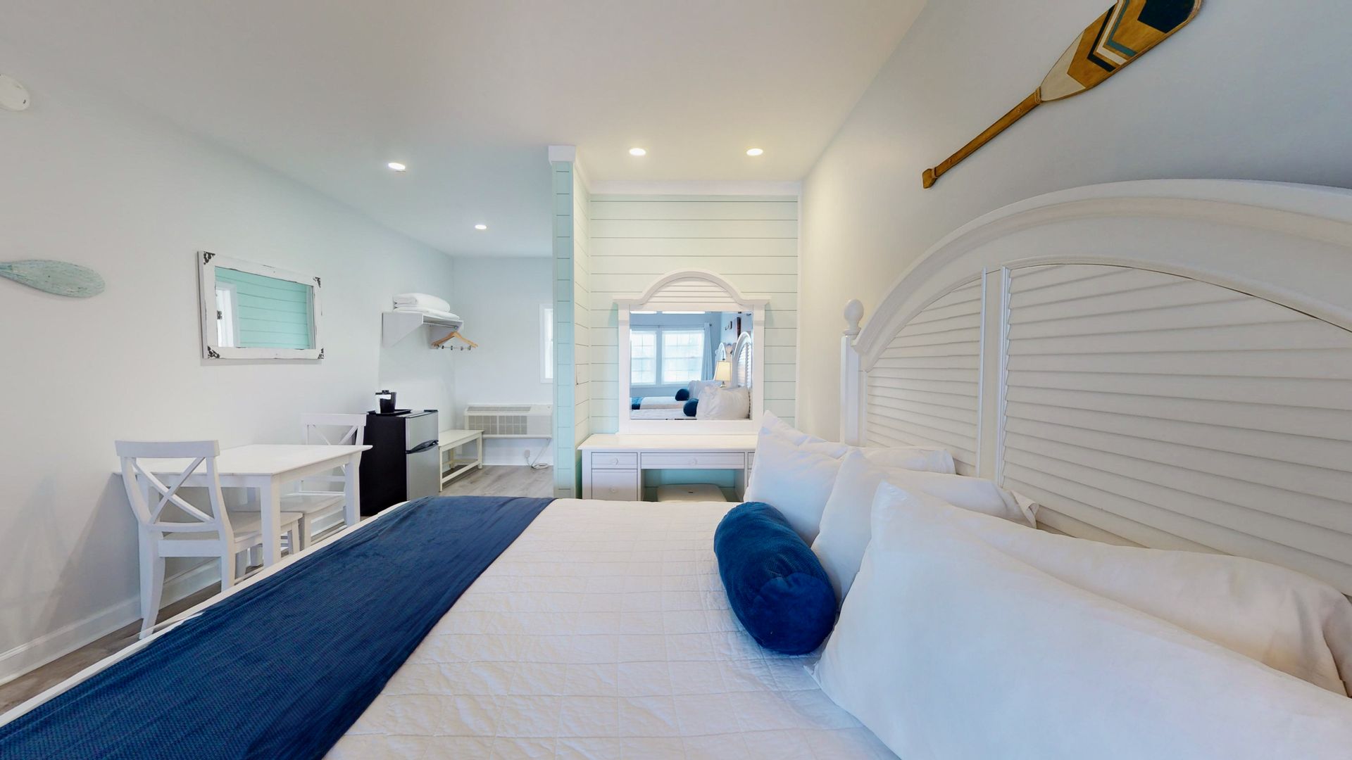 A hotel room with a king size bed , table and chairs.