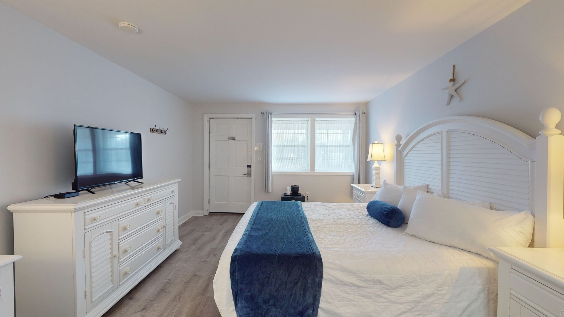 A hotel room with a king size bed and a flat screen tv.