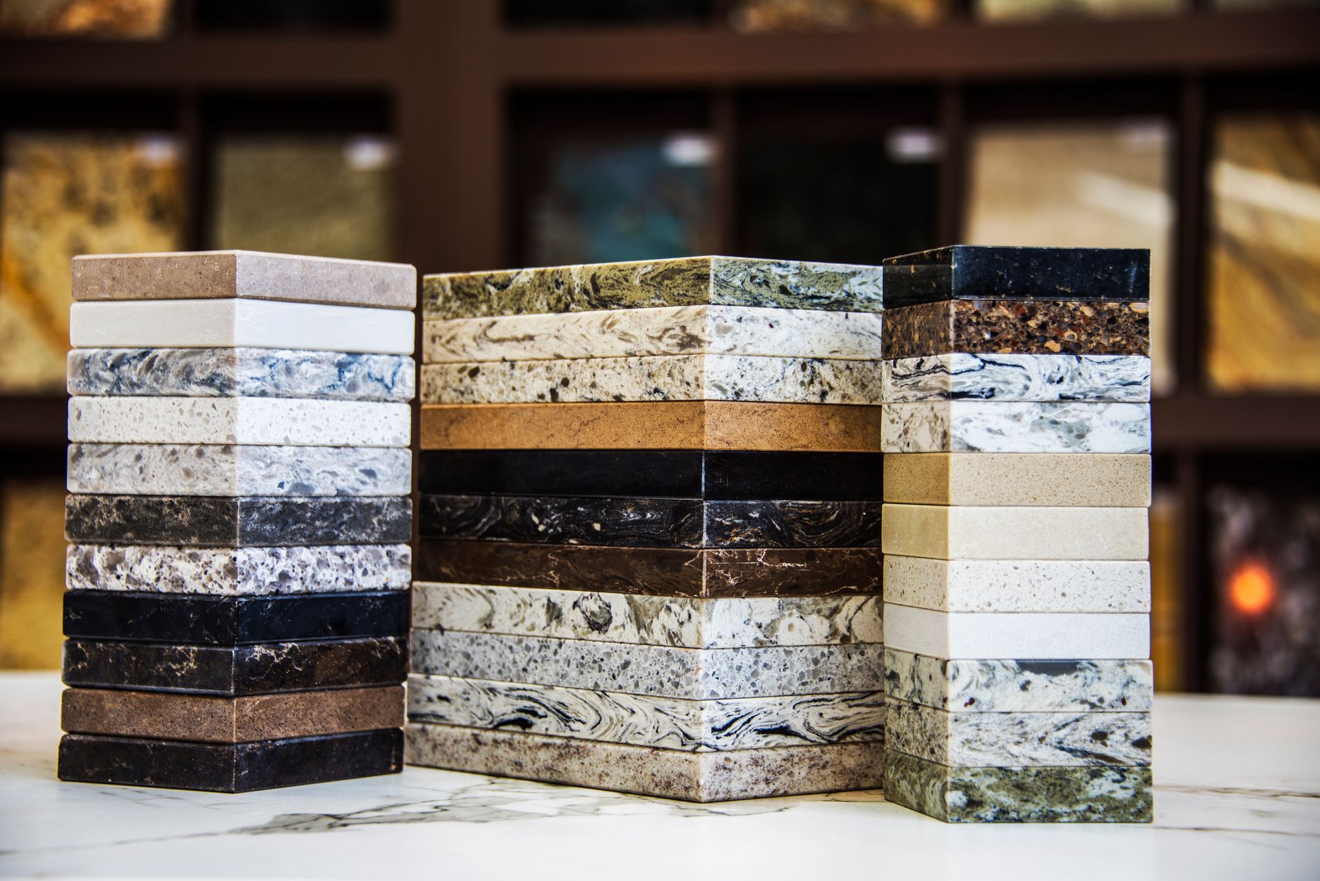 Stacks of granite countertop samples in various colors, displayed in a showroom setting. Stacks of granite countertop samples in various colors, displayed in a showroom setting.
