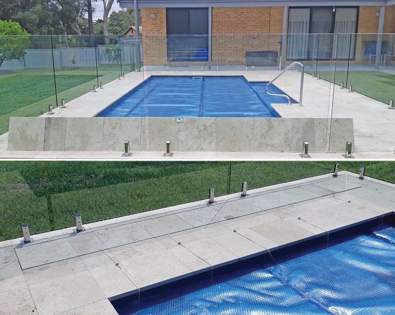 Pool with blue cover, concrete surround, and glass fencing.