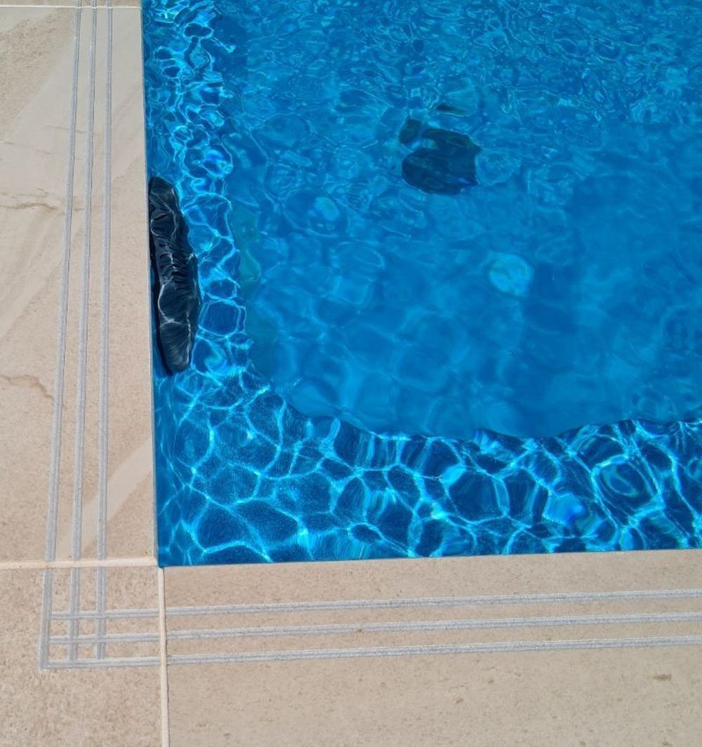 Blue pool water with stone border.