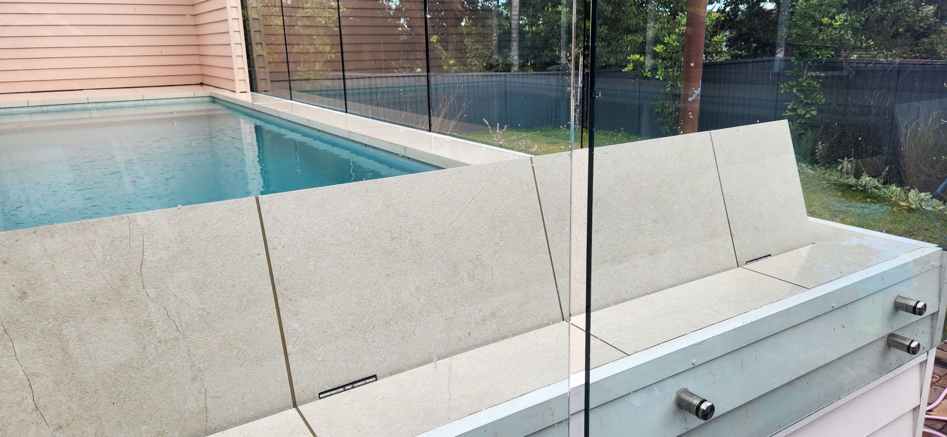 Gray composite deck with a dark, covered pool.
