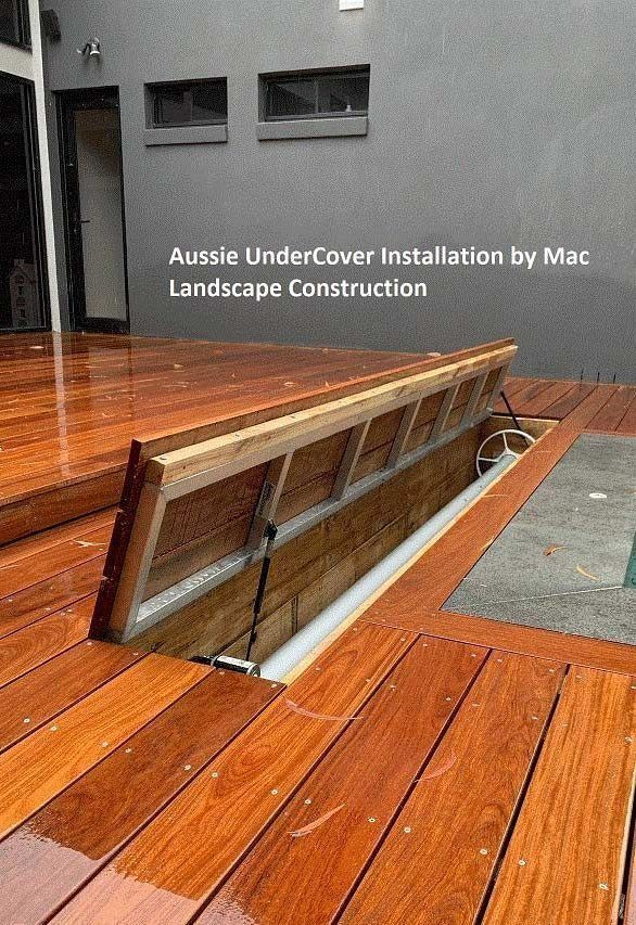 Wooden deck with a section raised, revealing an underground storage area. Text: