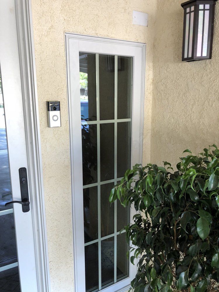 A door with a doorbell on it and a light on the wall.