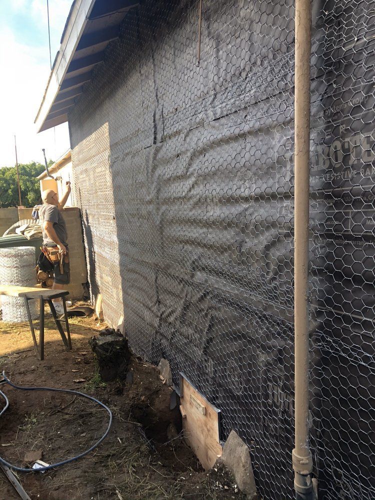 A man is working on the side of a house.