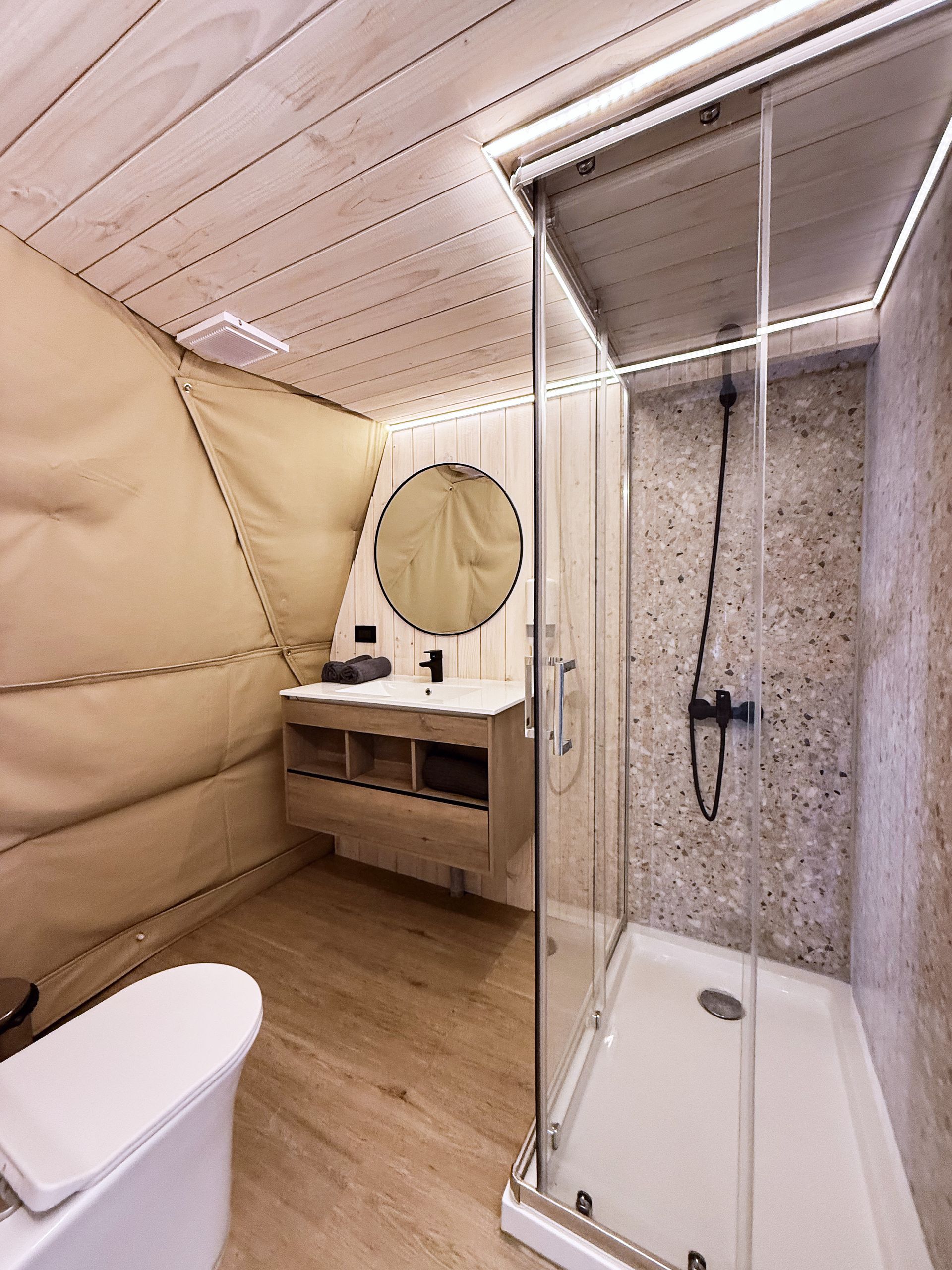 Interior de domo con camas, cocina , baño, toallas 