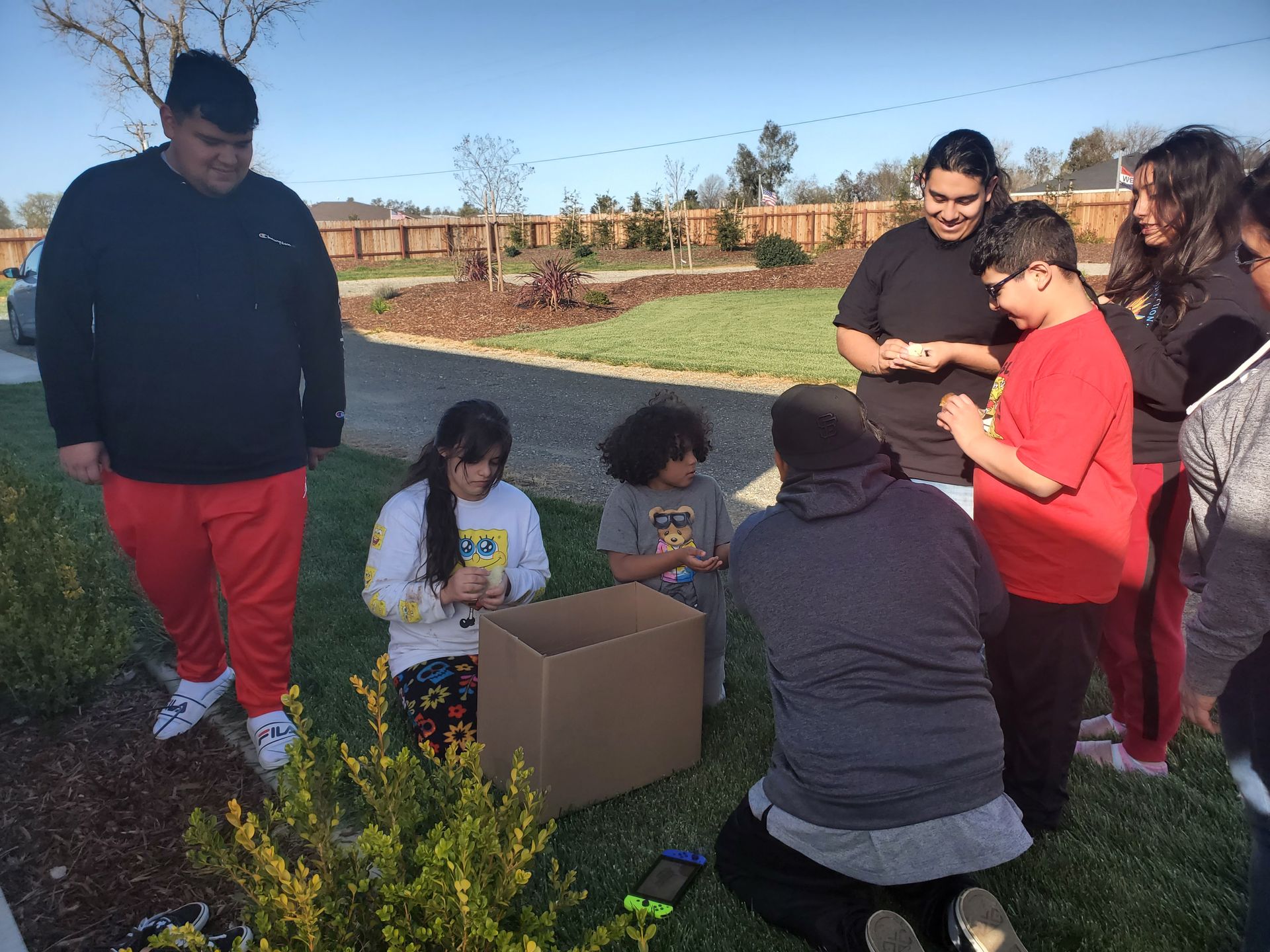 A group of people standing around a table with a box that says the tool supply on it