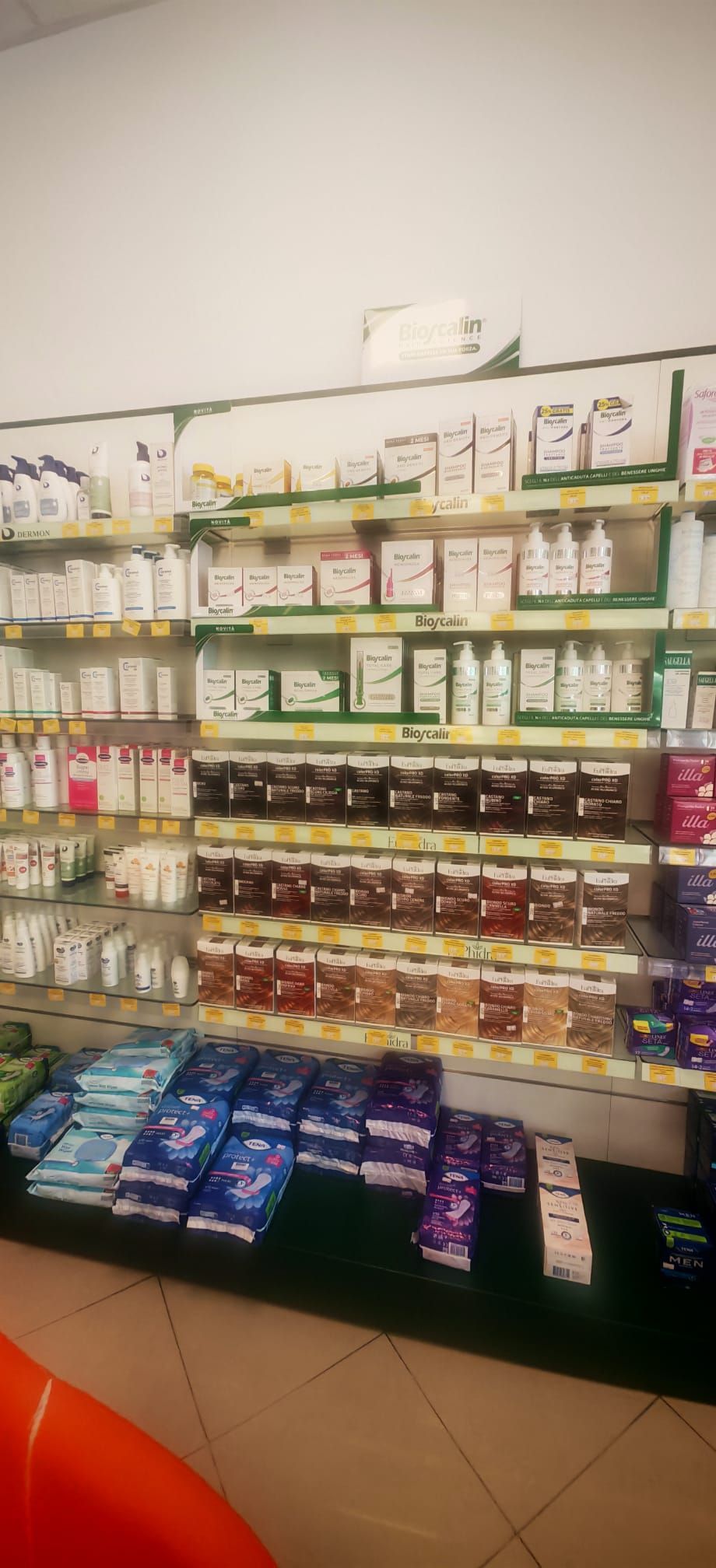 Scaffale del negozio pieno di snack confezionati assortiti e articoli alimentari disposti in file colorate