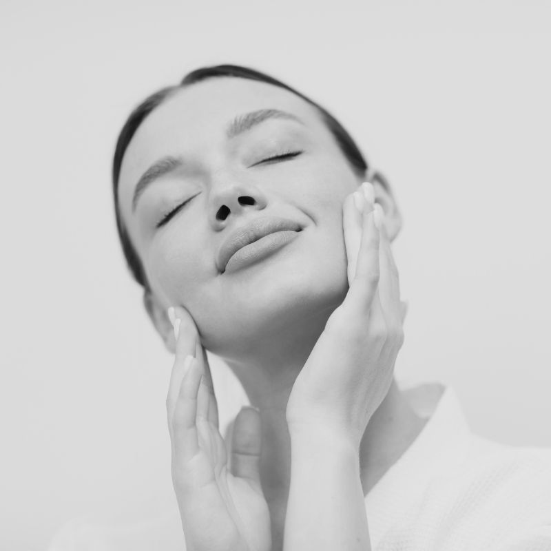 A patient's jaw and neck framed by a physician's hands before treatment at MAX MD Medical Aesthetics and Wellness in Garden City, NY