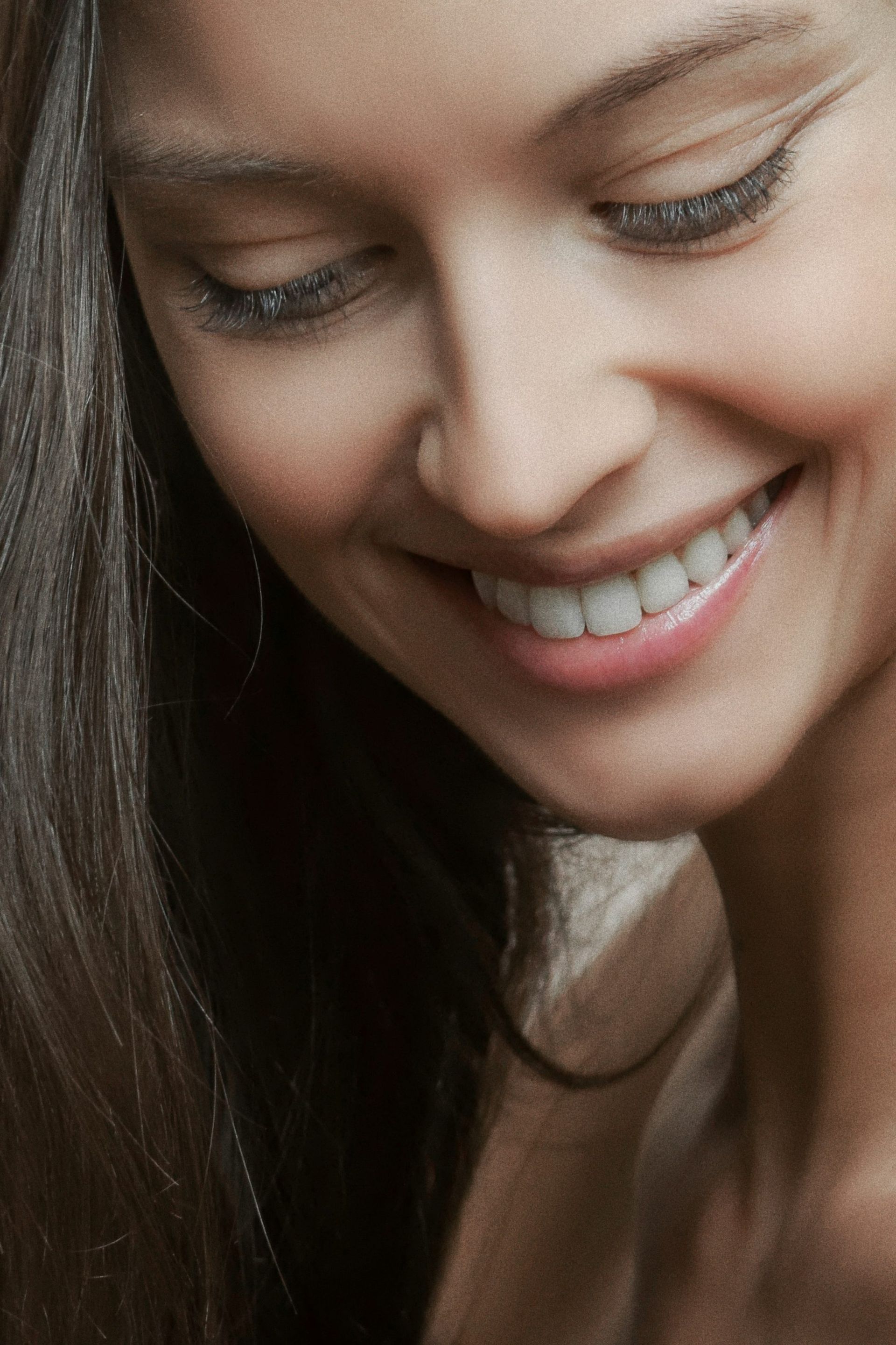 A relaxed, smiling beauty portrait in natural light at MAX MD Medical Aesthetics and Wellness in Garden City, NY