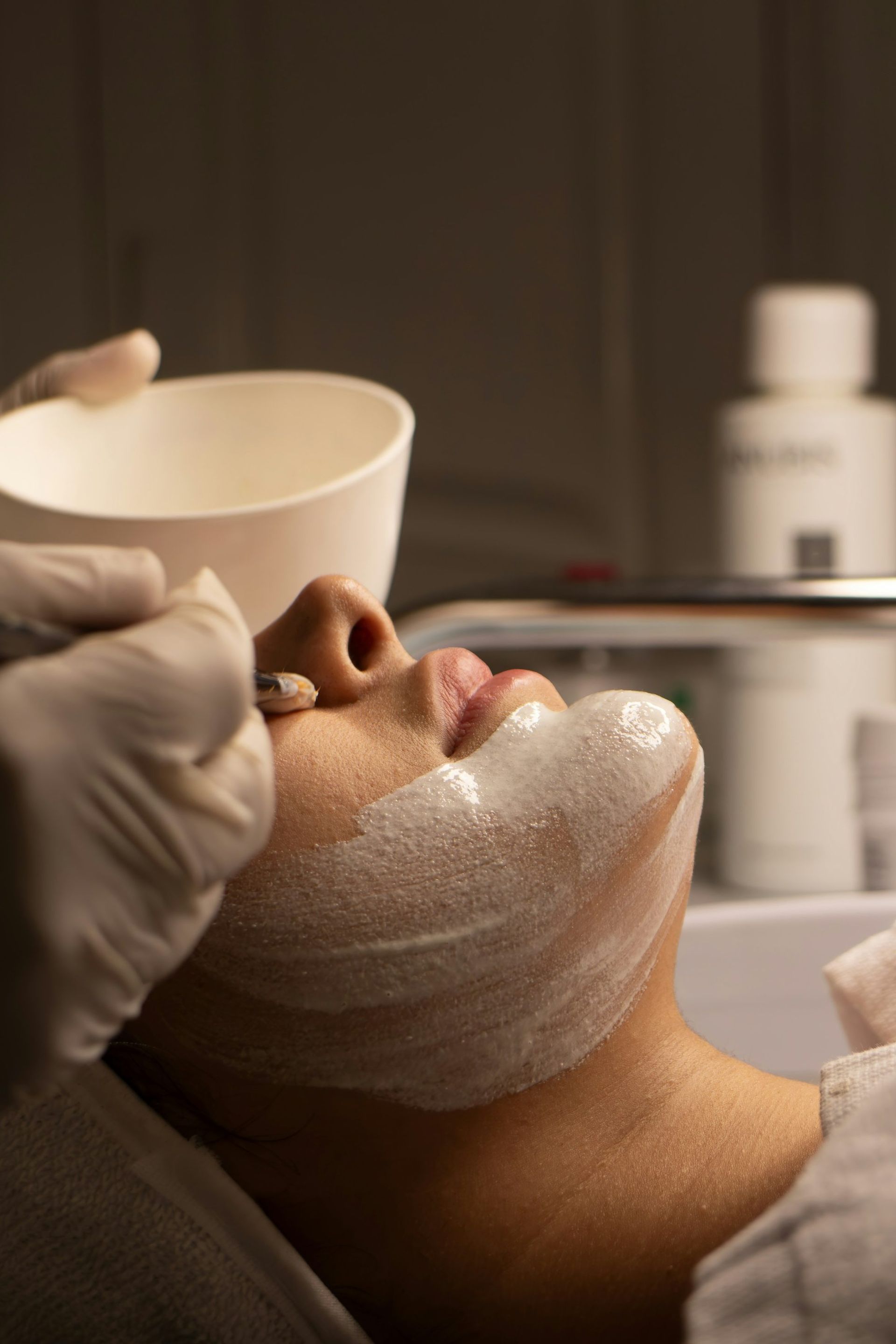 A patient receiving a facial treatment in warm, low light at MAX MD Medical Aesthetics and Wellness in Garden City, NY