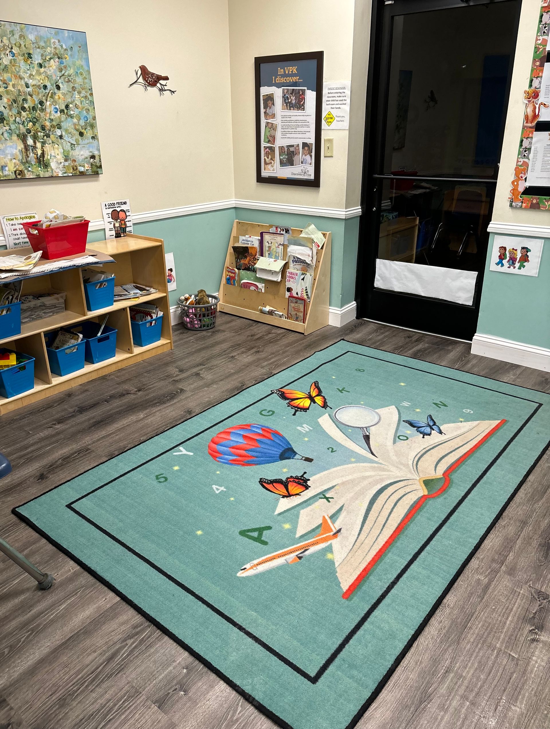 Person wearing blue gloves painting blue trim on a house with a paint roller.