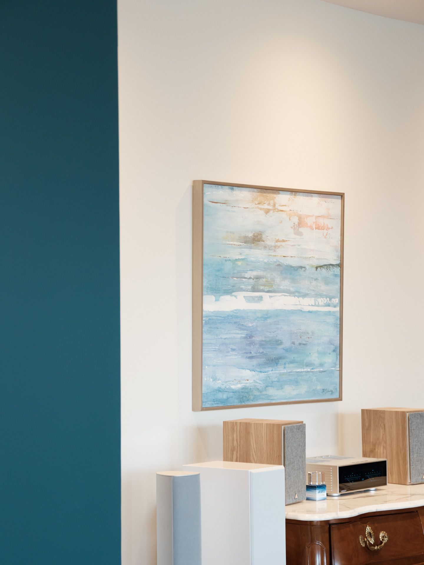 Two-story dark gray house with white trim, a balcony, and a tall chimney. Another brick house visible nearby.