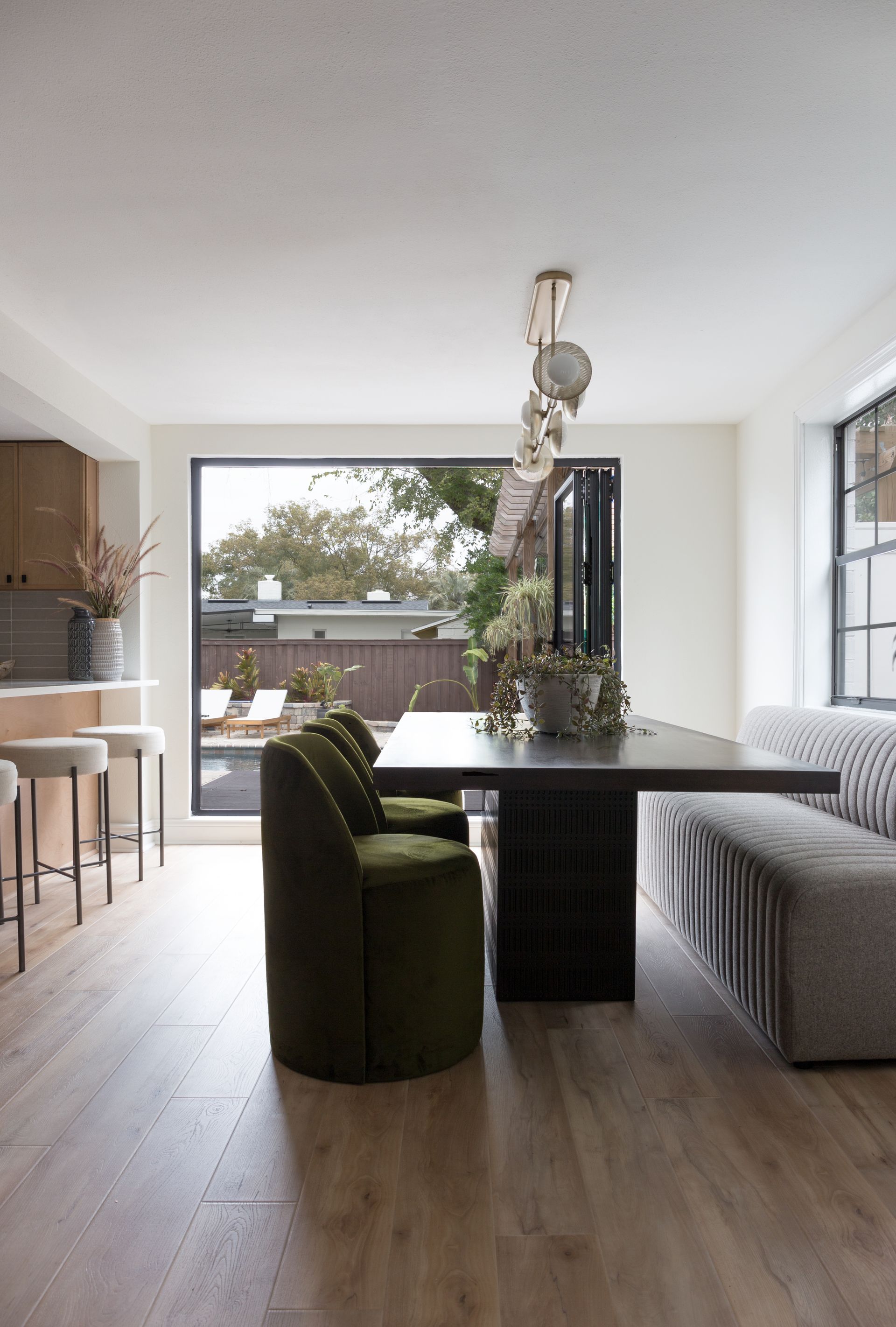 Navy blue powder room with arched doorway, marble floor, crystal light fixture, and white sink.
