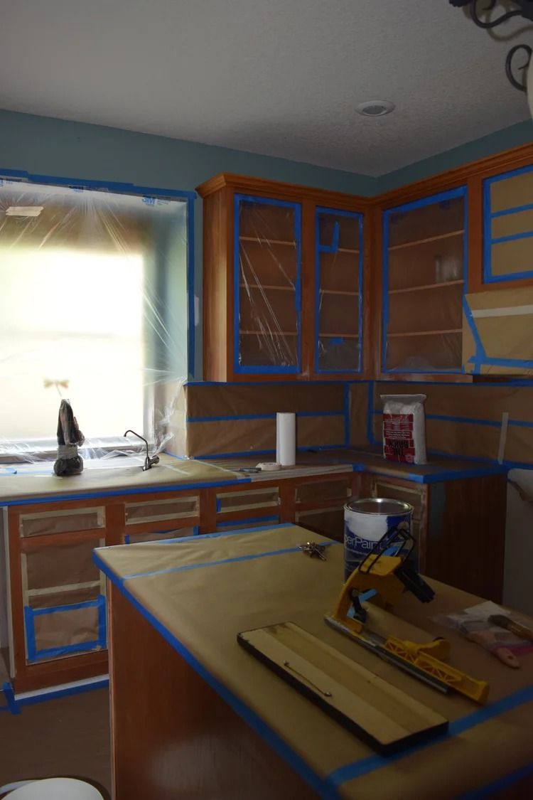 Kitchen cabinetry taped off and prepared for painting.