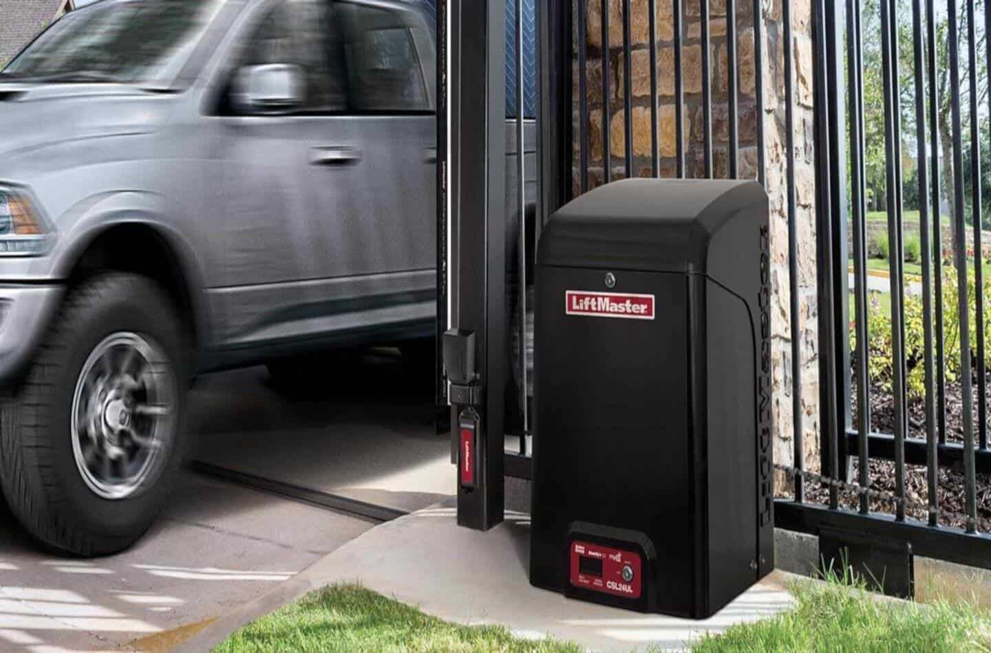 Silver SUV entering a driveway beside a black gate-mounted automatic opener box