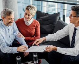 Three professionals reviewing a document together in a modern office lounge