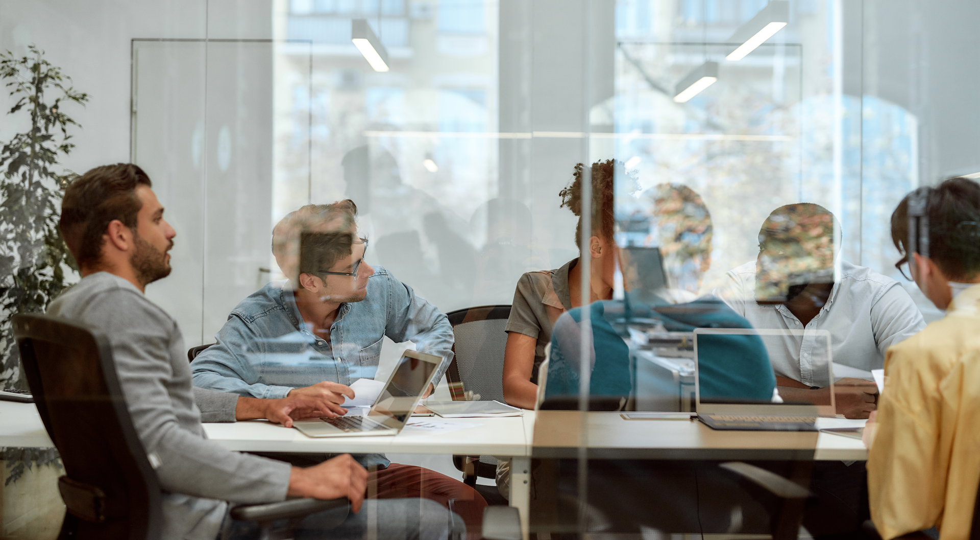 A group of people are sitting around a table in a conference room.