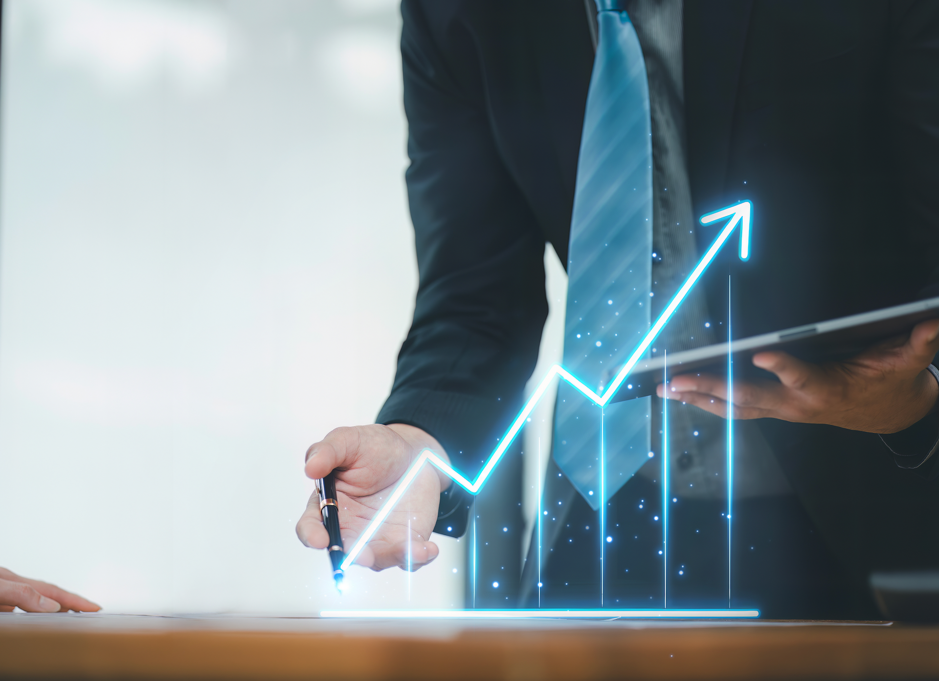 A man is pointing at a graph on a tablet.