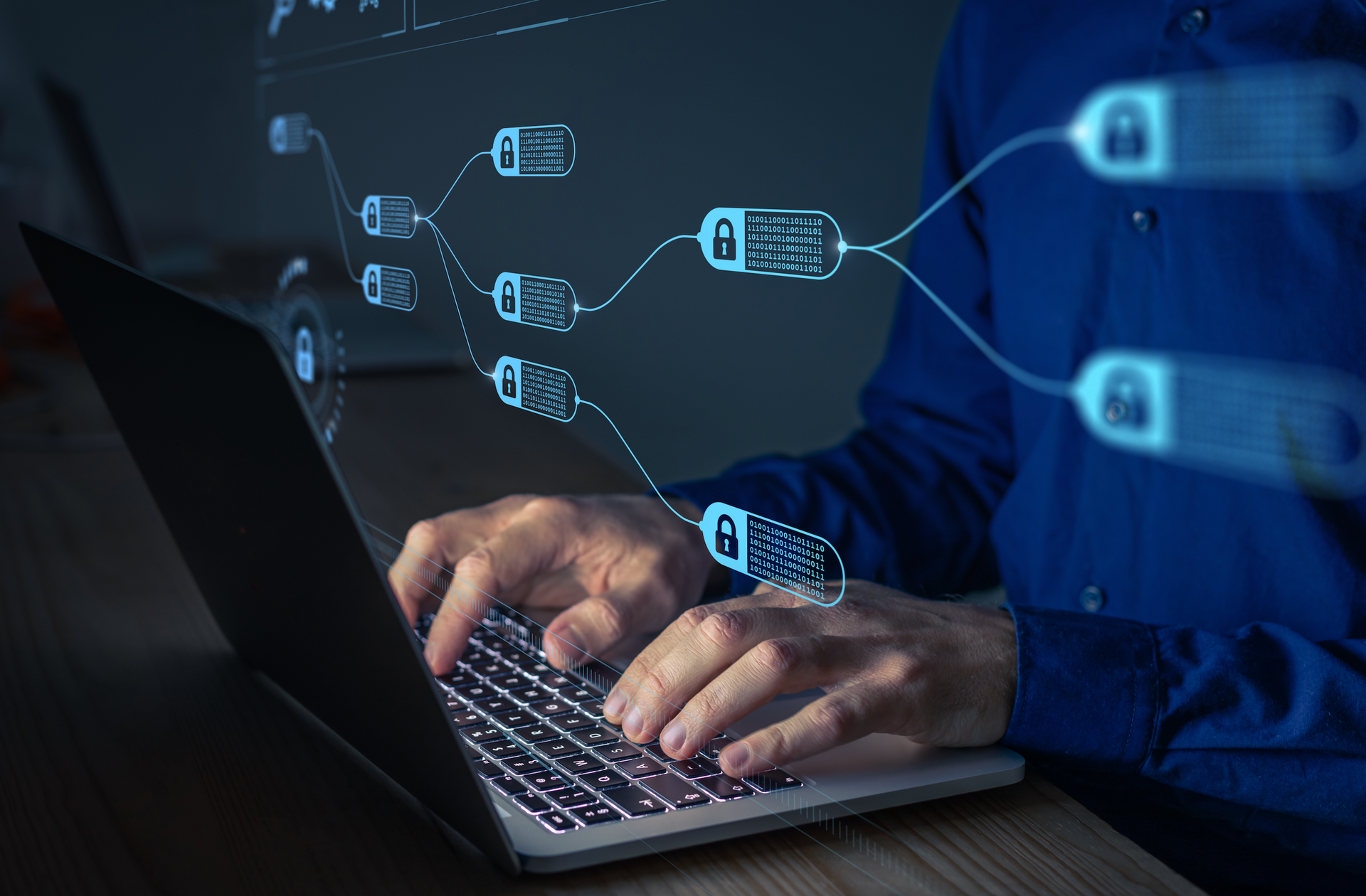 A man is typing on a laptop computer at night.