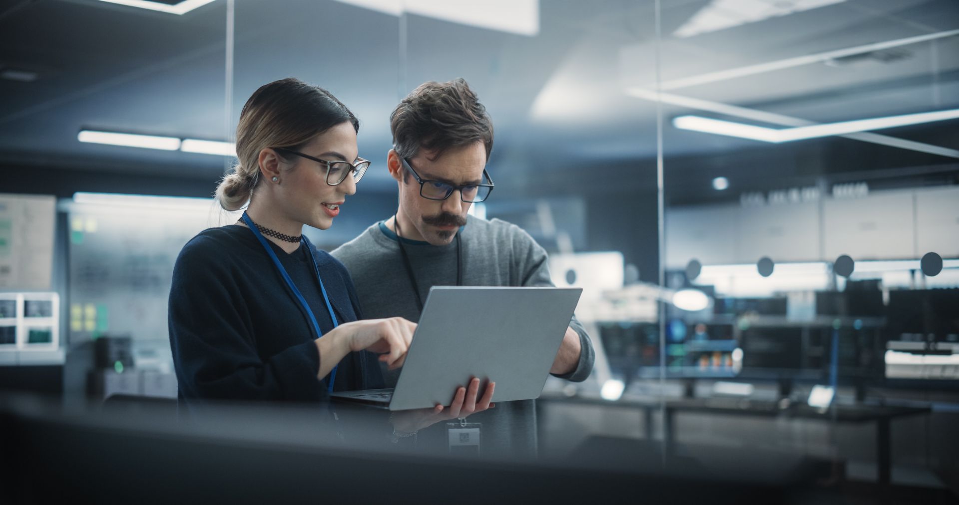 A man and a woman are looking at a laptop computer.