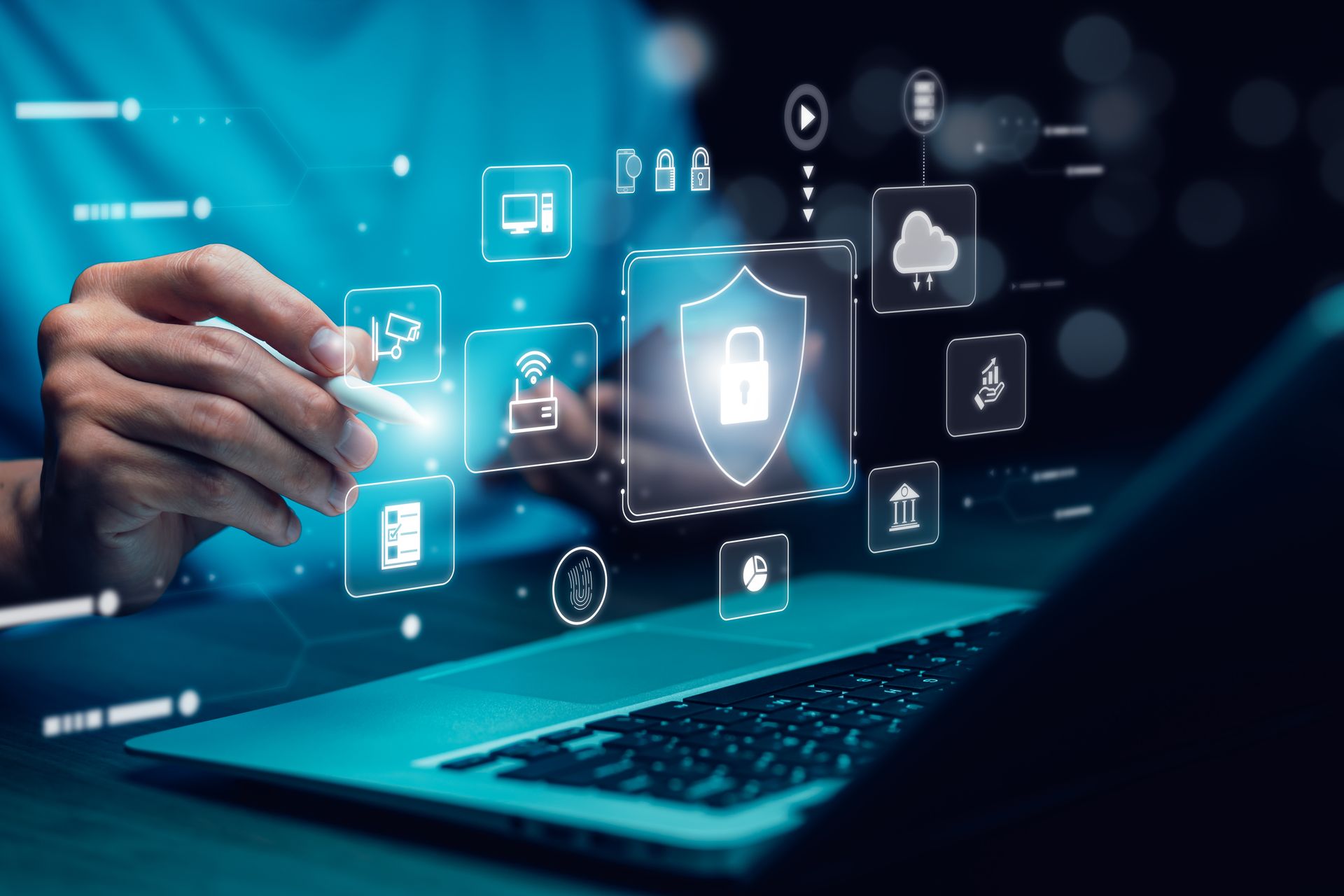 A person is using a laptop computer with a shield and icons coming out of it.