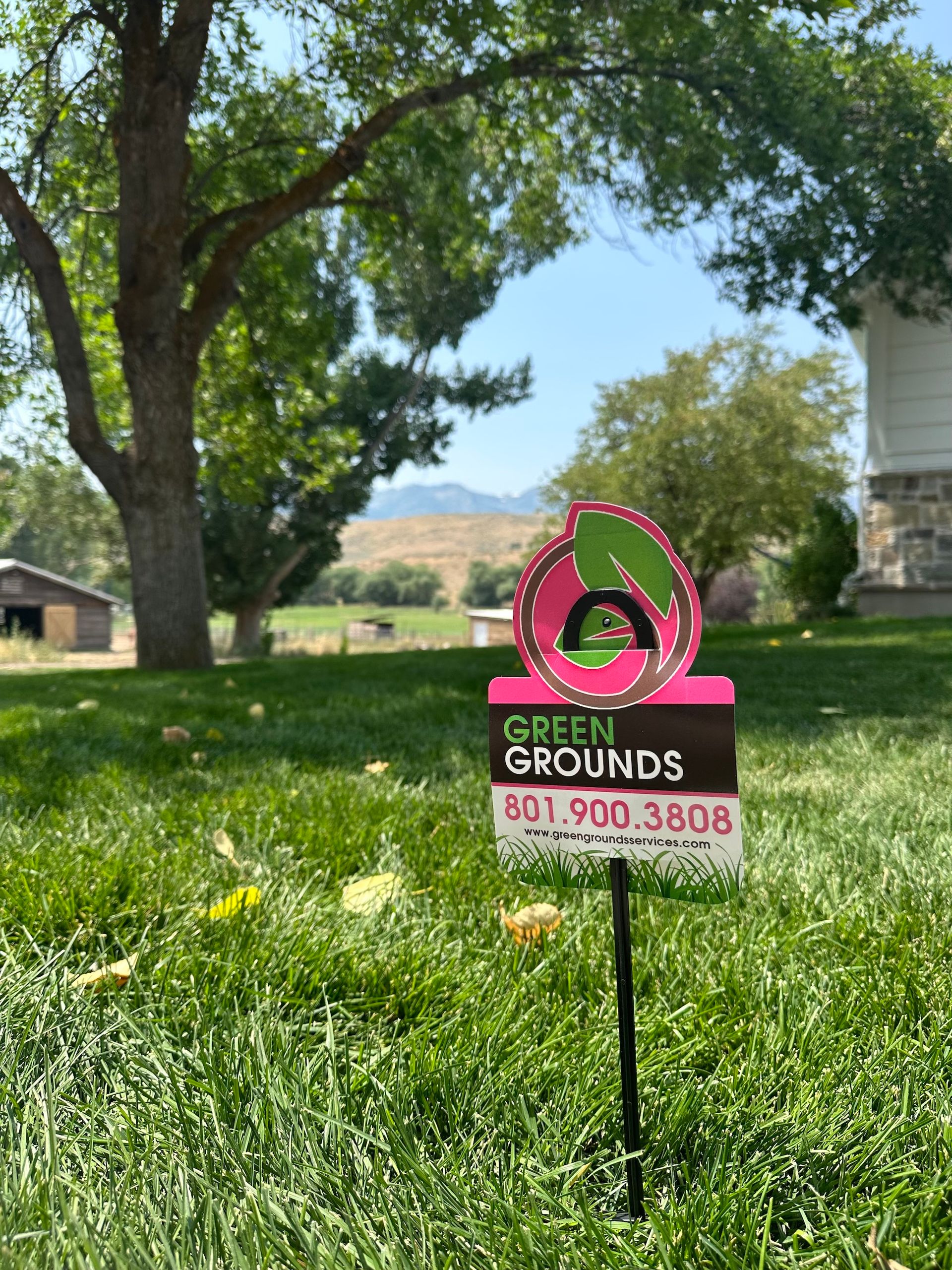 A sign in the grass that says green grounds