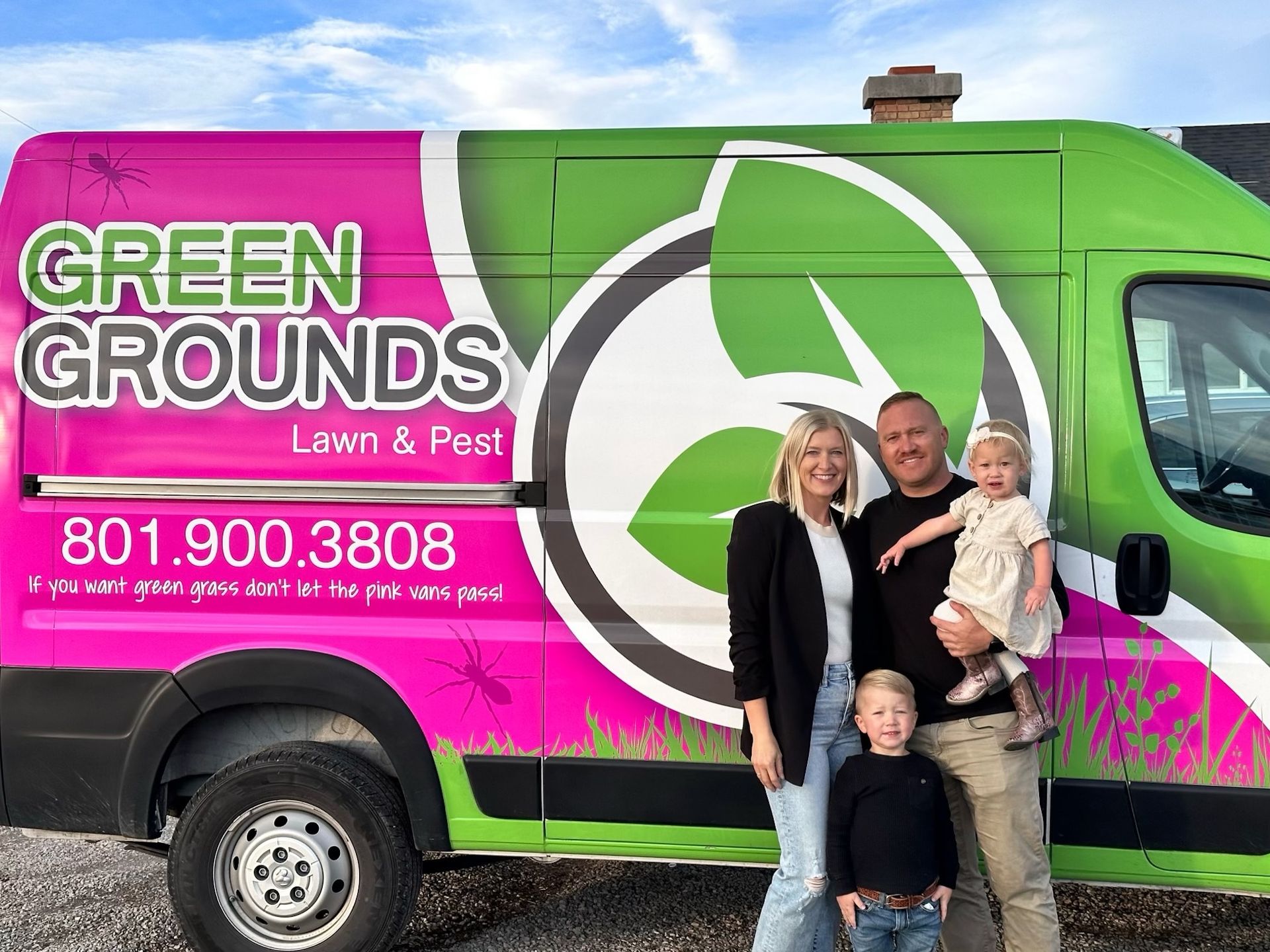 A family is standing in front of a green and pink van.