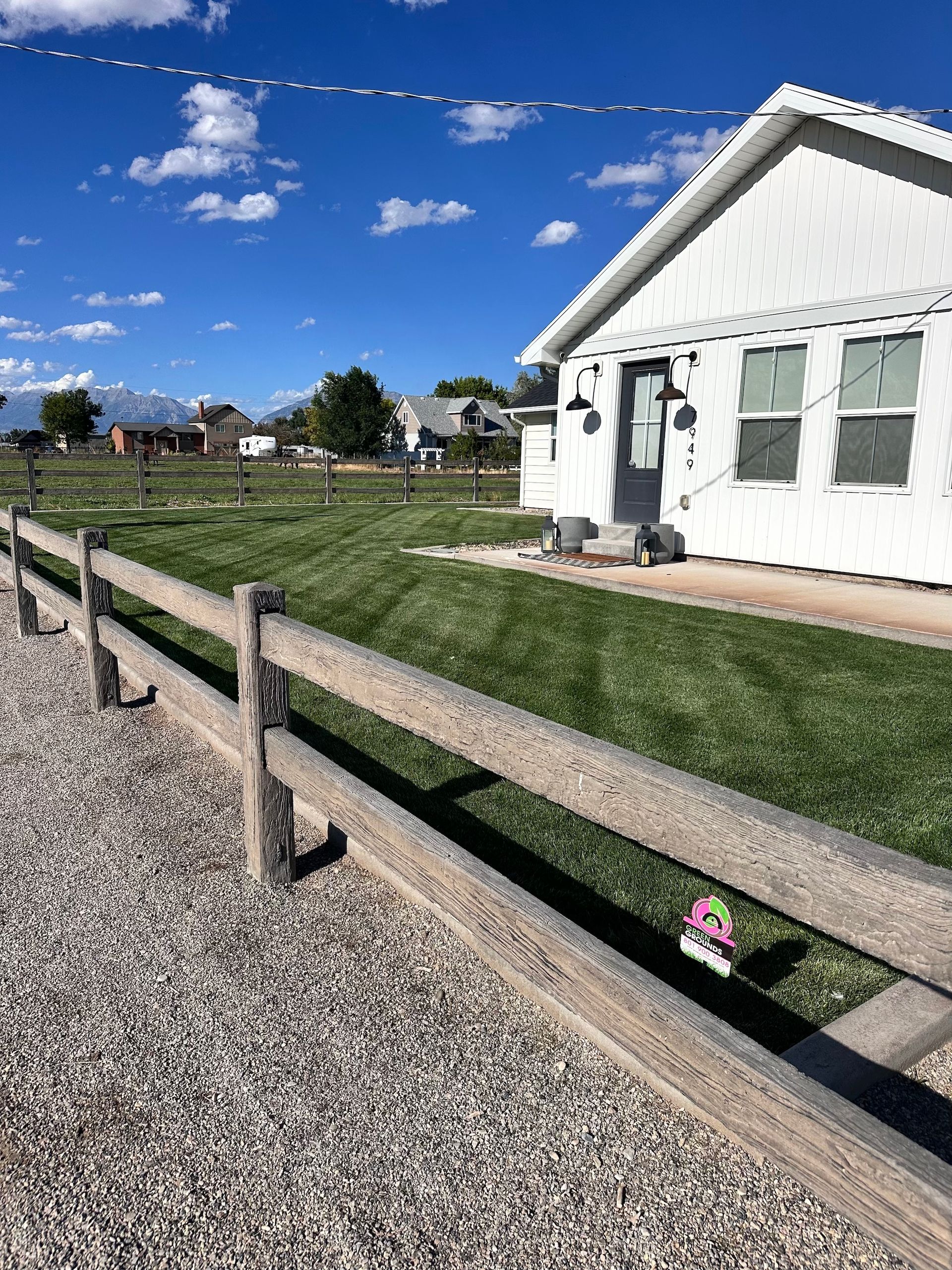 A white house with a wooden fence in front of it.